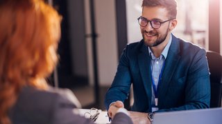 Happy bank manager shaking hands with a client after successful agreement in the office. Happy bank manager shaking hands with a client after successful agreement in the office.