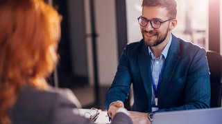 Happy bank manager shaking hands with a client after successful agreement in the office. Happy bank manager shaking hands with a client after successful agreement in the office.