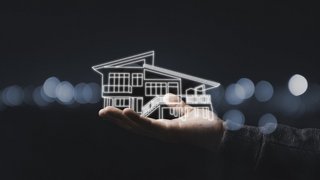 Business holding virtual infographic house on hand. Real estate investment concept.