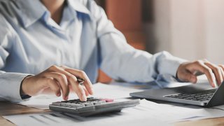 businesswoman working on desk using laptop for check data of finance in office