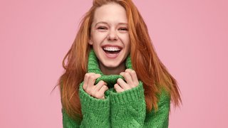 Bright laughing teenage girl on pink background