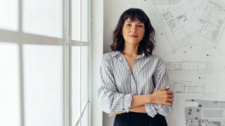 Confident female architect standing in office