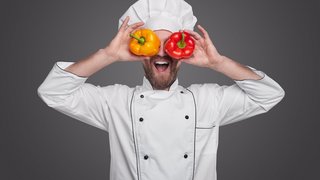 Cheerful chef with colorful peppers