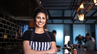 Portrait of a waitress standing with arms crossed
