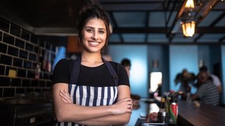 Portrait of a waitress standing with arms crossed