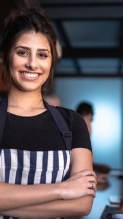 Portrait of a waitress standing with arms crossed