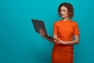 Serious woman keeping computer and typing