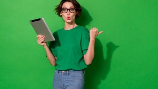 Photo of charming impressed woman dressed summer t-shirt eyewear typing gadget empty space isolated green color background